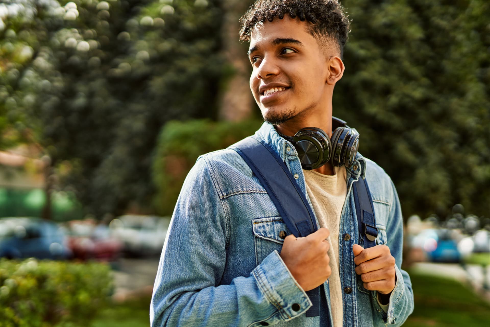 Jovem com fones de ouvido e mochila ao ar livre