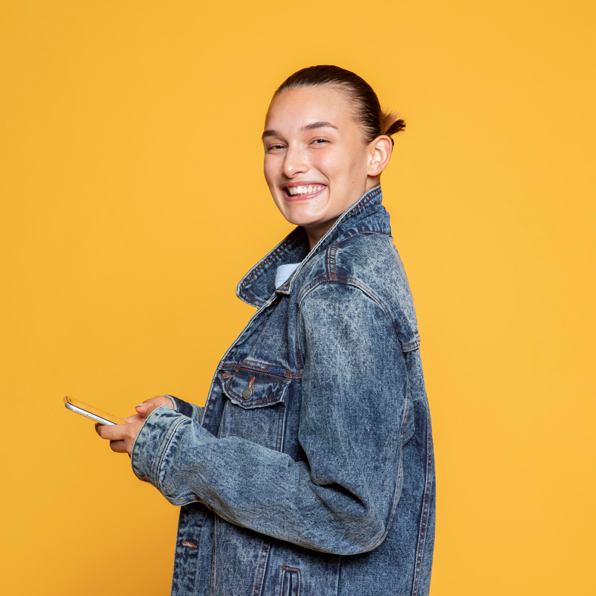 Jovem sorrindo segurando celular